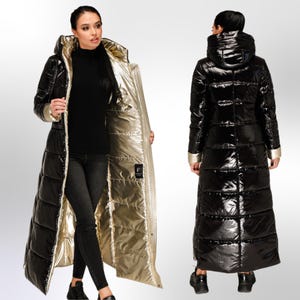 May include: A long, black puffer coat with a gold lining. The coat has a hood and is quilted. The coat is shown on a model wearing black jeans and sneakers.