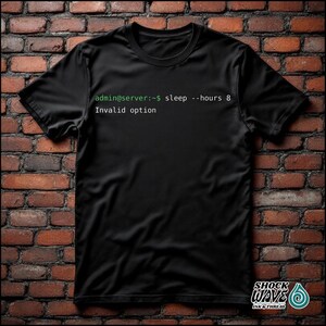 Può includere: T-shirt nero con la scritta "admin@server:~$ sleep --hours 8 Invalid option" in verde e bianco. La maglietta ha un girocollo e maniche corte. Il logo del marchio "SHOCK WAVE INK & THREAD" è in basso a destra.