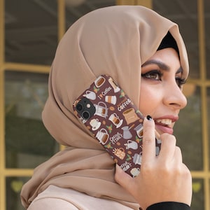 May include: A brown and white phone case with a coffee theme. The case features illustrations of coffee cups, coffee beans, and coffee makers. The text on the case says "I love coffee", "But first coffee", "Coffee time", and "Coffee break".