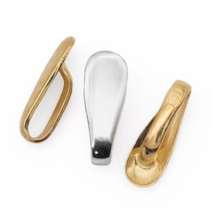May include: Three pendant bails, one silver and two gold. The gold bails have a slightly oval shape, while the silver bail is more rounded. All three bails have a smooth, polished finish.
