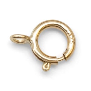 Könnte beinhalten: Vergoldeter Metallverschluss mit einem runden Ring und einer kleinen Schlaufe. Der Verschluss ist mit "375" gekennzeichnet.