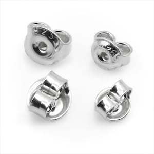 May include: Four silver earring backs, two with the number "925" stamped on them, and two without any markings.