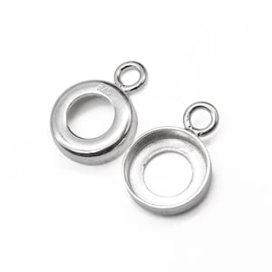 Op de afbeelding: Twee zilveren bezel-instellingen met een springring. De bezel-instellingen zijn rond en hebben een gladde afwerking. De springring is bevestigd aan de bovenkant van de bezel-instelling.