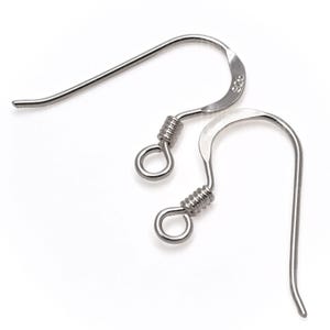 Peut inclure: Deux crochets de boucles d'oreilles argentés sur fond blanc. Chaque crochet présente un détail en fil enroulé près de la boucle et une conception incurvée. Les crochets sont en métal brillant.
