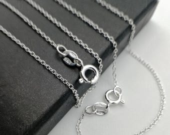 May include: A silver chain necklace with a lobster clasp fastening. The chain is made of small, linked ovals.