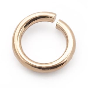 May include: A gold-toned jump ring, a type of jewellery finding, is a simple circle with a gap. It is used for connecting jewellery pieces.