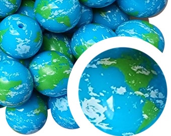 Könnte beinhalten: Nahaufnahme einer Ansammlung von blauen und grünen kugelförmigen Perlen. Die Perlen sind aus Kunststoff und haben eine strukturierte Oberfläche. Die Perlen haben einen Durchmesser von etwa 2,5 cm.