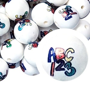 May include: White round beads with colorful ABC and 123 designs. The beads have a smooth surface and are ideal for crafting projects. The letters and numbers are in various colors, including blue, red, yellow, and green.