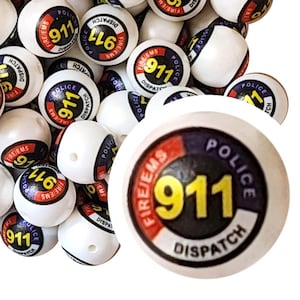 May include: White round beads with a 911 emergency services design. Each bead features the text "911", "Police", "Fire/EMS", and "Dispatch" in a circular design with red, white, blue, and yellow accents. The beads have a hole for stringing.