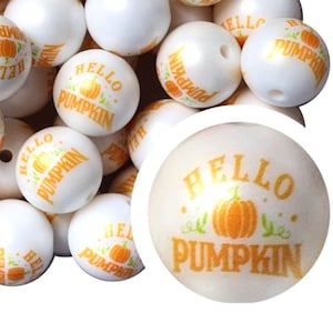May include: White round beads with the text "HELLO PUMPKIN" in orange, along with a pumpkin graphic. The beads are likely for crafting or jewelry making, perfect for fall-themed projects.