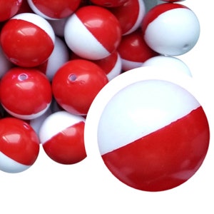 May include: A collection of red and white two-tone round beads. Each bead is divided diagonally, with one half red and the other white. The beads have a glossy finish and a hole for stringing. These beads are suitable for jewelry making and crafts.