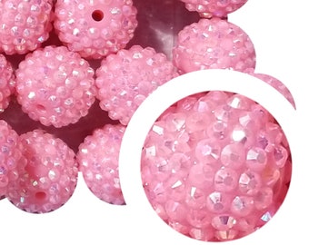Op de afbeelding: Een verzameling lichtroze, ronde kralen met een getextureerd, kristalachtig oppervlak. Elke kraal heeft een gat om te rijgen. De kralen zijn gegroepeerd, met een close-up die de details van het oppervlak laat zien.
