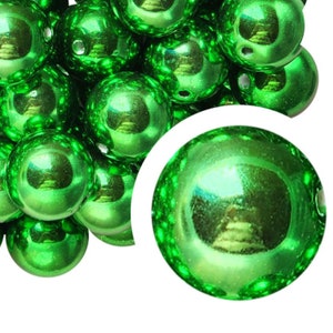 May include: A collection of shiny, emerald green, spherical beads. Each bead has a reflective, glossy surface with a small hole for stringing. The beads are clustered together, with one bead enlarged in a white circle.