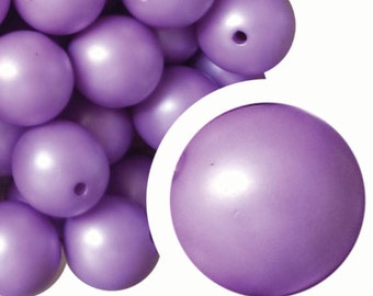 May include: A close-up of a pile of large, round, purple beads. The beads have a pearlescent finish and a hole in the center.