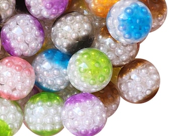 Pode incluir: Uma coleção de esferas decorativas coloridas. Cada esfera tem uma camada externa transparente preenchida com pequenas contas brancas semelhantes a pérolas. As esferas são em várias cores, incluindo roxo, rosa, azul, verde e dourado.