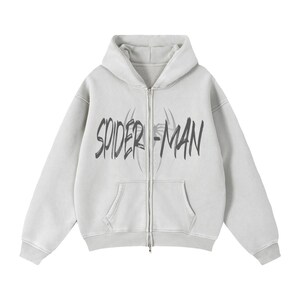 Puede incluir: Sudadera con capucha gris claro con cremallera, bolsillo delantero y capucha. La sudadera presenta las palabras "SPIDER-MAN" en una fuente negra desgastada en el pecho. El dise&ntilde;o incluye una telara&ntilde;a.