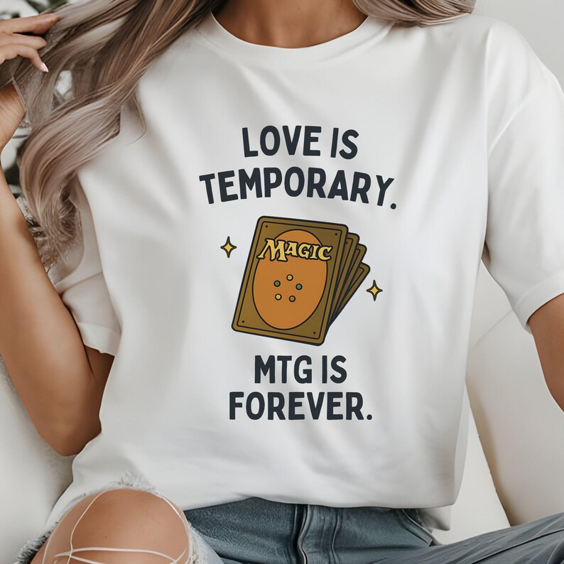 K&ouml;nnte beinhalten: Wei&szlig;es T-Shirt mit einem Grafikdruck eines Magic: The Gathering Kartenspiels und dem Text "Liebe ist verg&auml;nglich. MTG ist f&uuml;r immer."