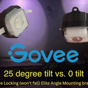 May include: Two Govee smart light bulbs mounted on black brackets. The left bulb is tilted at a 25 degree angle, while the right bulb is not tilted. The text "25 degree tilt vs. 0 tilt" is displayed below the bulbs. The text "Secure Locking (won't fall) Elite Angle Mounting brackets" is displayed below the text.
