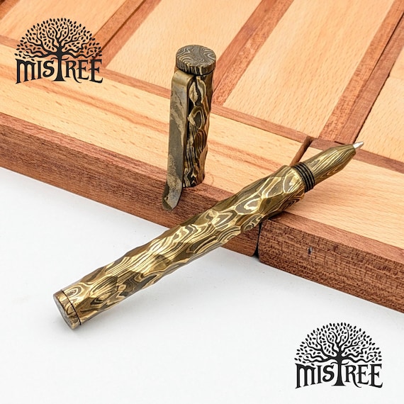 A fully functional ballpoint pen hand-forged in Damascus / Mokume Gane steel — the everyday carry object nobody has ever seen on a desk before.