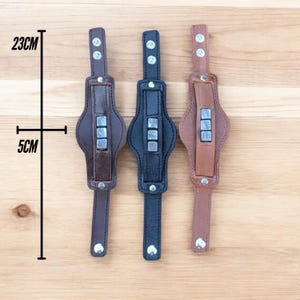 May include: Three leather bracelets with metal accents. The bracelets are 23 cm long and 5 cm wide. The bracelets are brown, black, and tan.