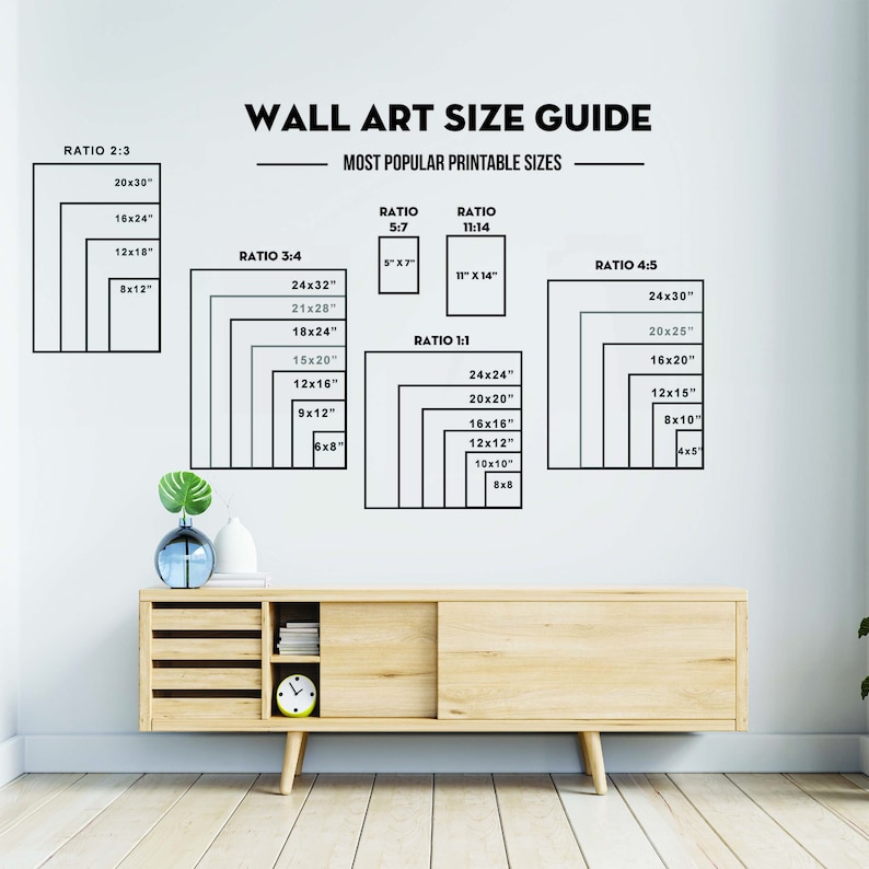 May include: A white wall with a chart showing different ratios for wall art sizes. The chart includes the ratios 2:3, 3:4, 5:7, 11:14, 4:5, and 1:1. The chart shows the dimensions of each ratio in inches. For example, the 2:3 ratio includes the dimensions 20x30, 16x24, 12x18, and 8x12. The chart is titled "Wall Art Size Guide" and "Most Popular Printable Sizes".