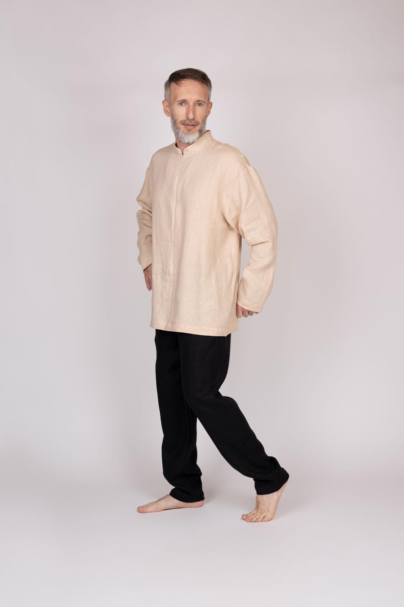 May include: A light beige long-sleeved shirt with a mandarin collar and black pants. The shirt is loose-fitting and the pants are straight-legged. The outfit is simple and comfortable, suitable for casual wear.