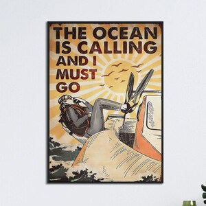 Może przedstawiać: Plakat w stylu vintage z nurkiem skaczącym z łodzi do oceanu. Plakat zawiera tekst "The Ocean is Calling and I Must Go" w pogrubionym, żółtym foncie.