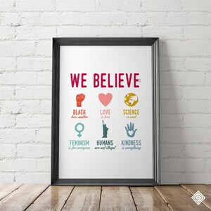 May include: A white poster with the text "WE BELIEVE" in red letters. The poster features six icons with text below each icon. The icons are a fist, a heart, a globe, a female symbol, the Statue of Liberty, and a hand. The text below the icons reads "Black lives matter", "Love is love", "Science is real", "Feminism is for everyone", "Humans are not illegal", and "Kindness is everything".
