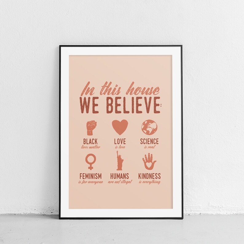 Pu&ograve; includere: Un poster rosa e marrone con il testo "In questa casa crediamo:" e un elenco di valori che includono "Le vite nere contano", "L'amore &egrave; amore", "La scienza &egrave; reale", "Il femminismo &egrave; per tutti", "Gli umani non sono illegali" e "La gentilezza &egrave; tutto".