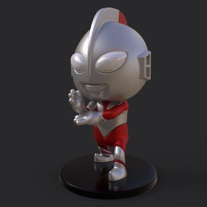 May include: A silver and red figurine of a character with a large head, oval eyes, and a smiling expression. The figure is posed with one hand raised. It stands on a black circular base. The figurine is a collectible item.