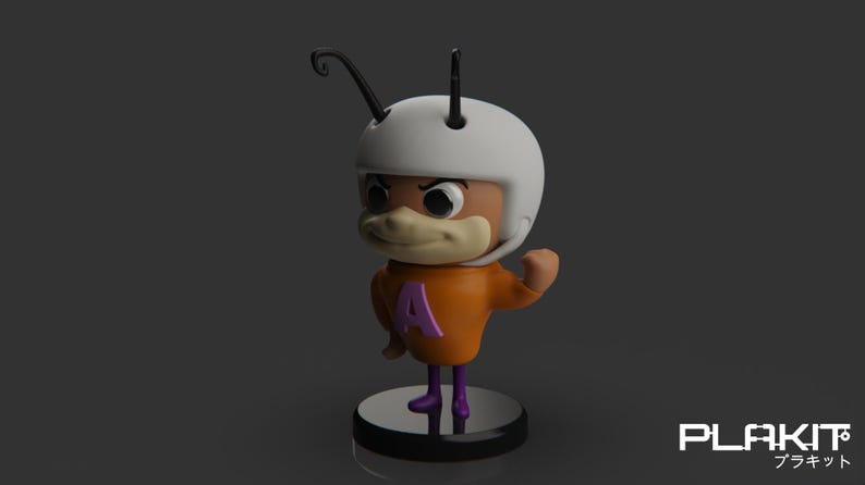 Puede incluir: Una peque&ntilde;a figura naranja y morada de un personaje de dibujos animados que lleva un casco blanco con una antena negra. El personaje tiene una nariz grande y marr&oacute;n y levanta el brazo derecho en un pu&ntilde;o.