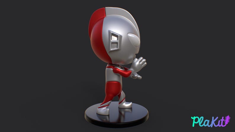 May include: A stylized figurine of a superhero in a dynamic pose. The figure features a red and silver color scheme, with a rounded head and detailed facial features. It stands on a black circular base, with the "PlaKit" logo in the bottom right corner.