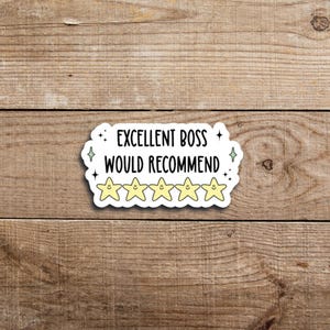 May include: A white sticker with the text "EXCELLENT BOSS WOULD RECOMMEND" in black. Below the text are five yellow star emojis with smiling faces. The sticker has a white border with small green star accents.