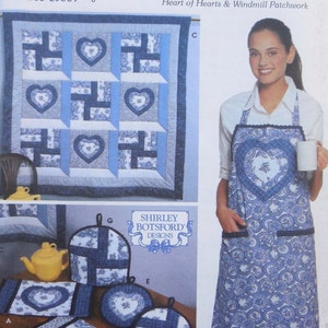 May include: A blue and white patchwork quilt with a heart design. The quilt is made up of squares with a windmill pattern. The quilt is surrounded by a white border. The quilt is labeled "Heart of Hearts & Windmill Patchwork".