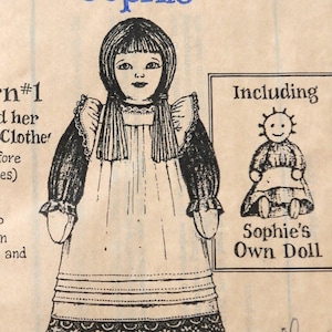 Könnte beinhalten: Eine Schwarzweißillustration einer Puppe, die ein langes Kleid mit einer Spitzenborte trägt. Die Puppe hat langes Haar und ein einfaches Gesicht. Das Bild enthält den Text "Including Sophie's Own Doll" und "700".