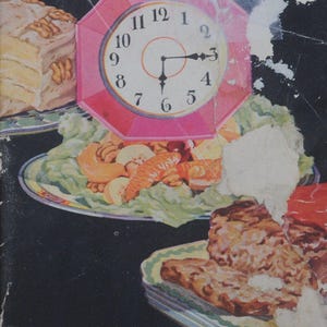 Puede incluir: Libro de cocina vintage titulado "Around the Kitchen Clock with Walnuts". La portada negra presenta una ilustración de reloj rosa e imágenes de comida. El texto es amarillo y el libro mide unos 15 cm de largo.