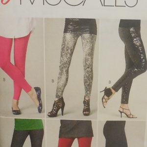 May include: A sewing pattern for leggings by Easy McCall's. The pattern features various styles of leggings in different colors and patterns, including solid pink, patterned, and black leggings. The pattern size is Y (Xsm-Sml-Med).