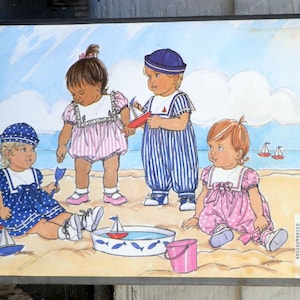 May include: A sewing pattern for children's clothing, featuring four children playing on a beach. The pattern is called "Busybodies" and is for sizes L-XL. The children are wearing sailor-themed outfits in blue, pink, and white.