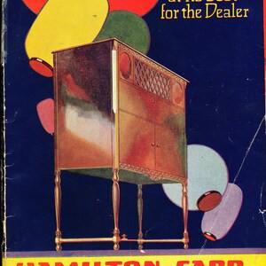 May include: A vintage advertisement for Hamilton-Carr Radio Corporation featuring a wooden radio cabinet with a decorative grille and a yellow, red, and blue colour scheme. The text reads "Radio at its best for the Dealer" and "Hamilton-Carr Radio Corporation 700 Eagle St. Chicago, Ill."