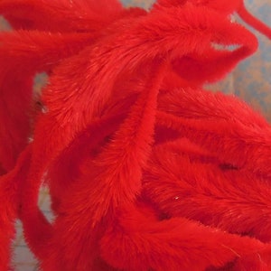 May include: A pile of red fuzzy pipe cleaners. The pipe cleaners are soft and flexible, and they are perfect for crafting.