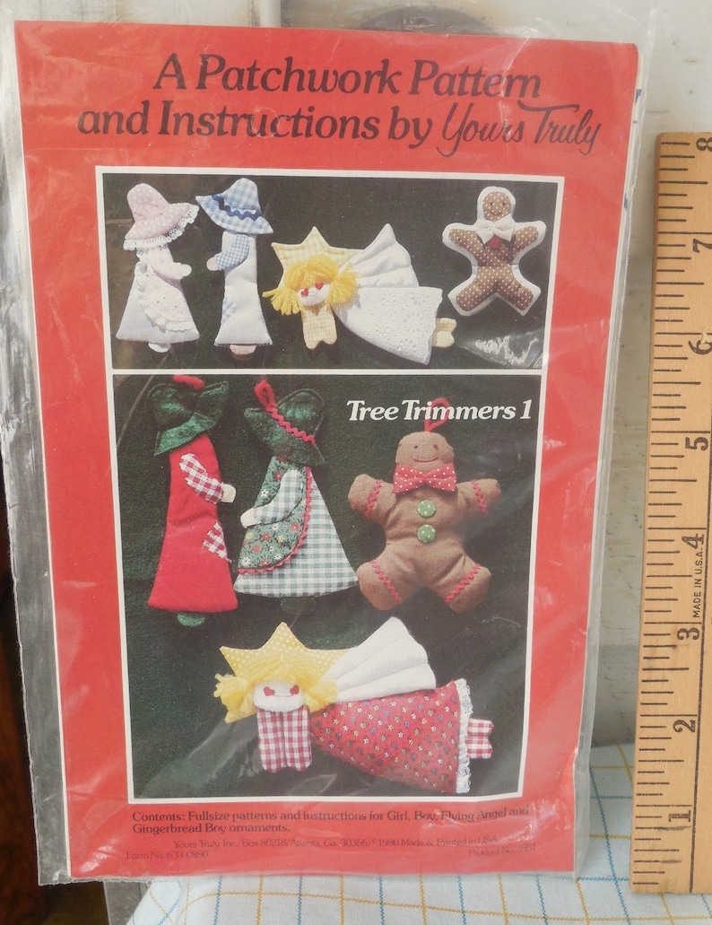 May include: A package for a patchwork pattern and instructions by Yours Truly. The cover features illustrations of handmade Christmas tree ornaments, including angels, gingerbread people, and figures in dresses and hats. The text reads "Tree Trimmers 1".