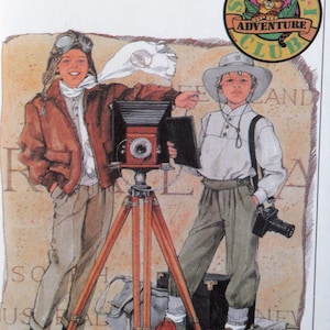 May include: Two young explorers, one wearing a brown leather jacket and goggles, the other wearing a white safari hat, stand with a vintage camera on a tripod. The camera is pointed towards the right. The background is a brown and white map with the words "SAFARI ADVENTURE CLUB" and "AUSTRALIA" visible.