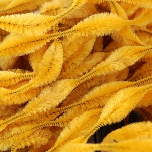 May include: A close-up of a pile of yellow pipe cleaners. The pipe cleaners are soft and fluffy, and they are perfect for crafting.
