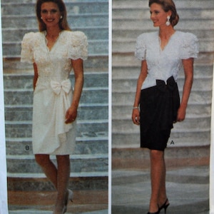 May include: Two evening dresses are displayed. One is a white dress with a bow at the waist and a ruffled skirt. The other is a black skirt paired with a white lace top. Both outfits have short, puffy sleeves.