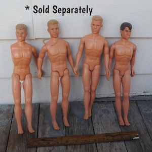 May include: Four vintage male fashion dolls with different hairstyles and skin tones. The dolls are nude and standing upright. A wooden ruler is at the bottom of the image. The text "Sold Separately" is at the top of the image.