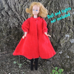 May include: A vintage doll wearing a bright red coat with a rounded collar and puffy sleeves. The doll has blonde hair and is wearing black tights. The text on the image reads "Doll and tights not included."