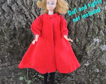 May include: A vintage doll wearing a bright red coat with a rounded collar and puffy sleeves. The doll has blonde hair and is wearing black tights. The text on the image reads "Doll and tights not included."