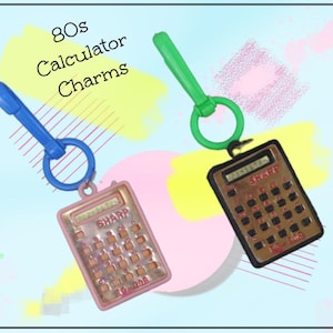 May include: Two vintage calculator charms from the 80s. One is pink with a blue clip, the other is brown with a green clip. Both charms have a ring and the word "SHARP" on them. The text "80s Calculator Charms" is in the upper left corner.
