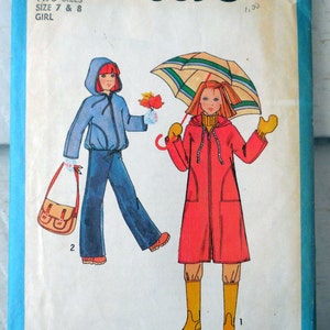 Może przedstawiać: Wz&oacute;r szycia Simplicity numer 8630 na płaszcz przeciwdeszczowy i kurtkę dla dziewczynki. Wz&oacute;r zawiera dwa rozmiary, 7 i 8. Ilustracja przedstawia dwie dziewczynki w ubraniach, jedna w niebieskiej kurtce, a druga w czerwonym płaszczu przeciwdeszczowym.