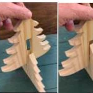 May include: A wooden Christmas tree decoration, shown in four stages of assembly. The tree is made of light-coloured wood and features a slotted design for easy construction. The image shows the pieces being joined together to form the tree.